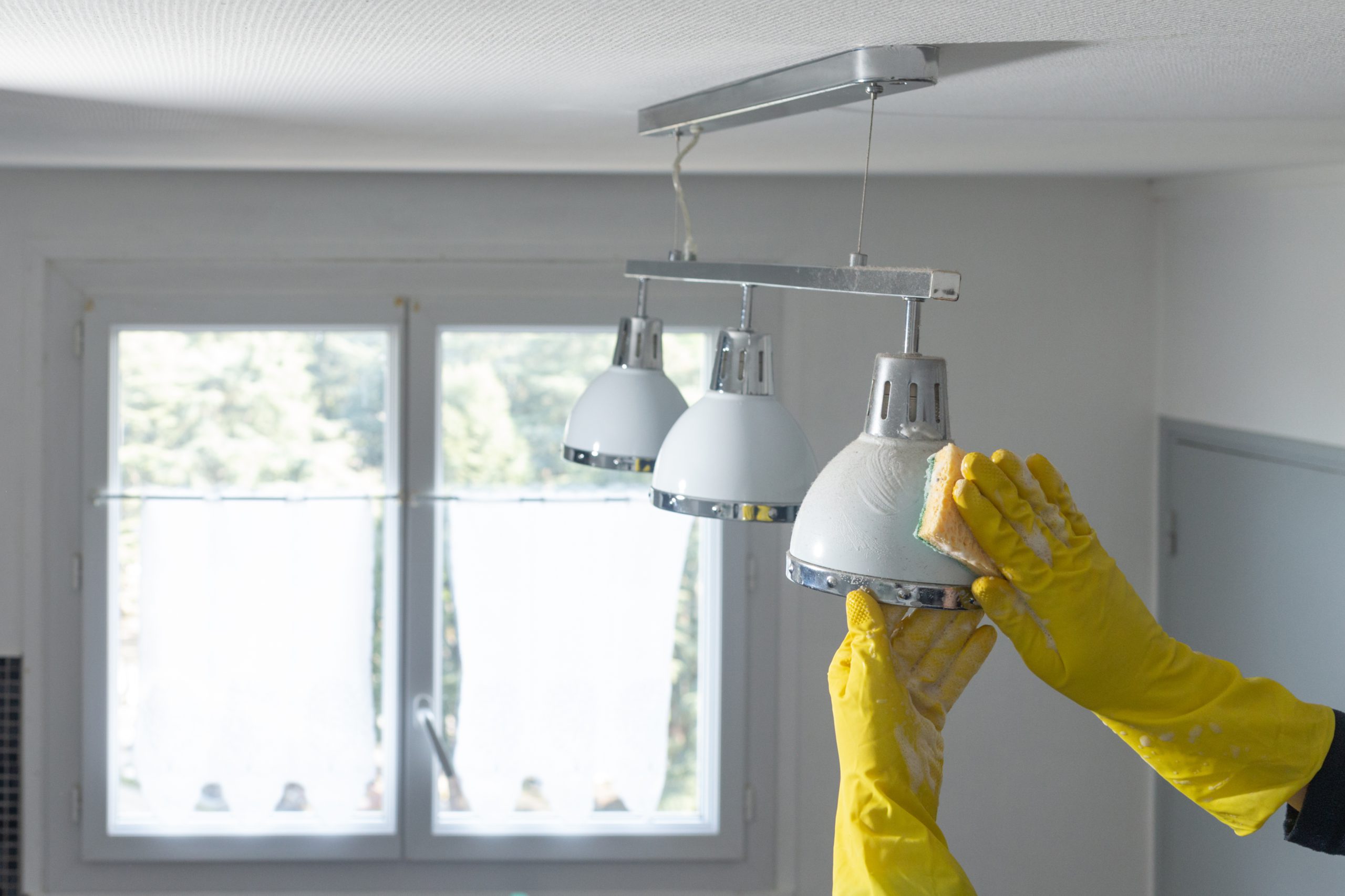 a cleaner wiping a lamp for end of tenancy cleaning London
